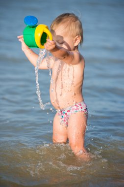 Şirin Bebek kumlu plajı ve deniz suyu oynarken.