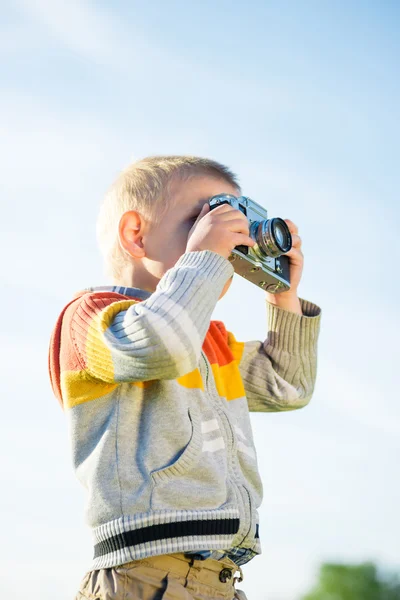Kleine jongen met een oude camera schieten buiten. — Stockfoto