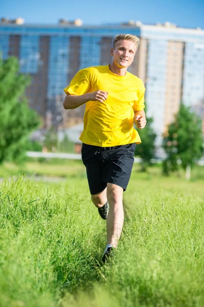 Sportieve man joggen in straat skyline van de stad. Buiten fitness. — Stockfoto