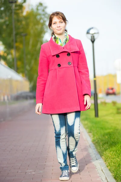 Belle femme en manteau rouge marchant rue d'automne . — Photo