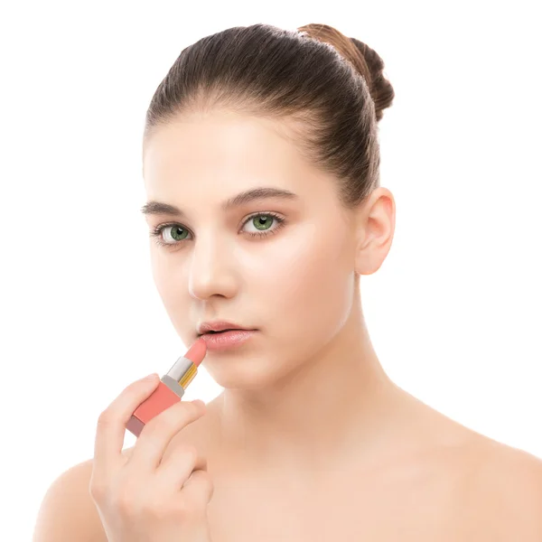 Young brunette woman with perfect clean face applying lipstick. Isolated on a white. — Stock Photo, Image