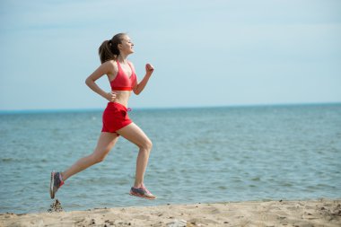 Güneşli yaz kum plajda çalışan genç bayan. Egzersiz. Jog