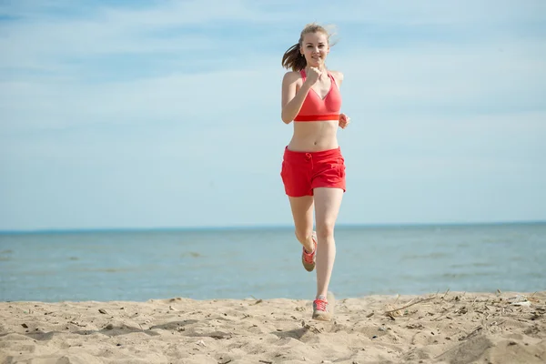 Giovane signora che corre alla soleggiata spiaggia di sabbia estiva. Allenati. Jogging — Foto Stock