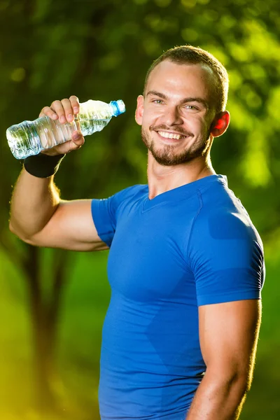 Sportovní zralý muž pitnou vodu z láhve — Stock fotografie