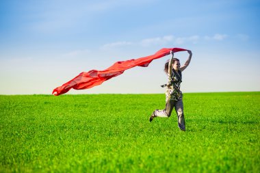 Güzel ve genç birbayan renkli doku ile yeşil çayır üzerinde atlama