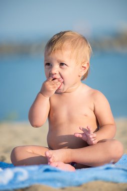 Şirin Bebek denize yakın kum plajındaki oyuncaklar ile oynama.