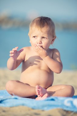 Şirin Bebek denize yakın kum plajındaki oyuncaklar ile oynama.