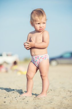 Şirin Bebek denize yakın kum plajındaki oyuncaklar ile oynama.