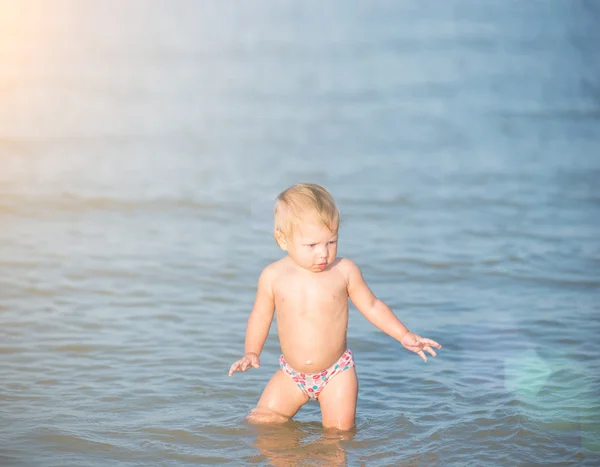 Симпатичный ребенок, играющий на песчаном пляже и в морской воде . — стоковое фото