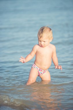 Şirin Bebek kumlu plajı ve deniz suyu oynarken.