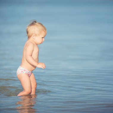 Şirin Bebek kumlu plajı ve deniz suyu oynarken.