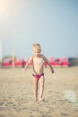 Kumsal deniz kenarında yürürken erkek sevimli bebek. Okyanus kıyısı.