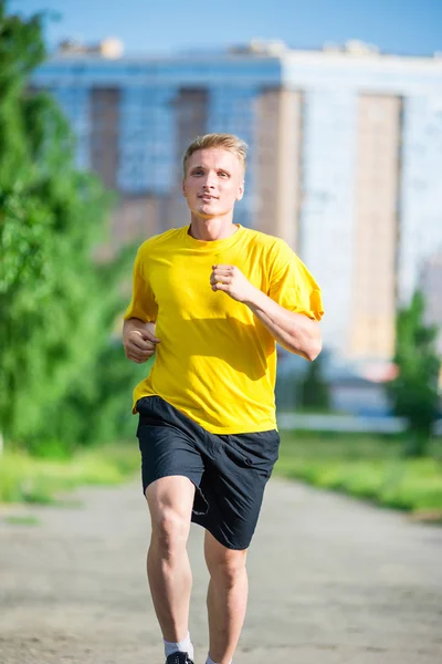 Sportovní muž, běhání v městském parku ulici. Venkovní fitness. — Stock fotografie