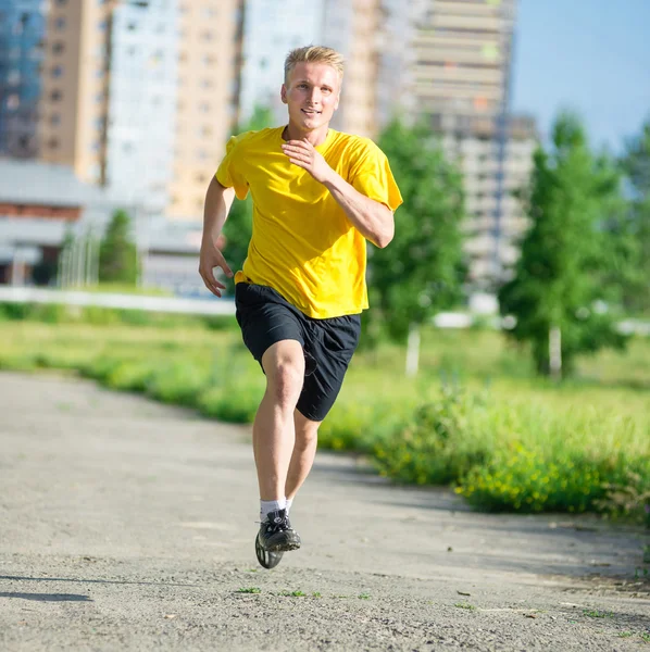 Sporty man jogging in city street park. Outdoor fitness. — Stock Photo, Image