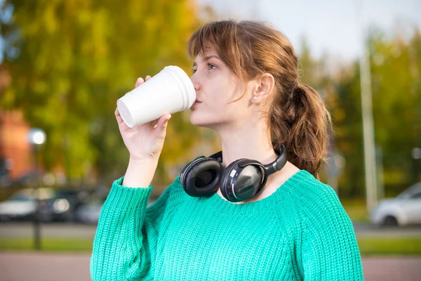 Happy young student girl drinking take away coffee. — Stock Photo, Image