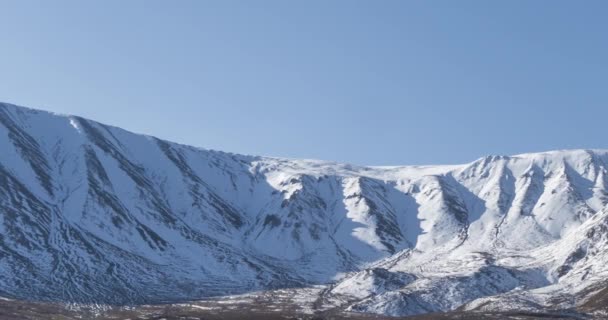 Timelapse del movimento del sole sul cielo cristallino sopra la cima della montagna della neve. Erba gialla al prato autunnale. Selvaggia natura infinita. — Video Stock