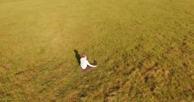 Yeşil çimlerin üzerinde sarı kırsal alanda not defteri olan bir adamın etrafında alçak yörünge uçuşları..