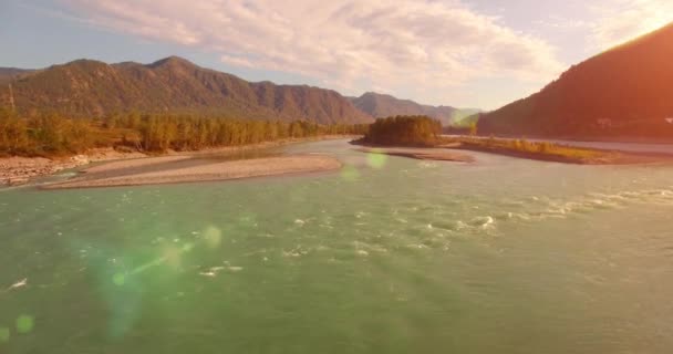 4k UHD航空ビュー。晴れた夏の朝に新鮮な冷たい山の川の上に低飛行。地平線の緑の木と太陽の光 — ストック動画