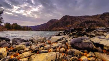 Zaman atlamalı bir nehir dağ orman kenarında bir kadeh. Büyük kayalar ve hızlı bulutlar movenings. Yatay kaydırıcı hareket