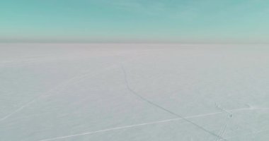 Soğuk kış manzarası kutup bölgesi, karla kaplı ağaçlar, ufukta buz nehri ve güneş ışınları. Aşırı düşük sıcaklık havası.