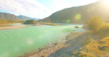 Güneşli yaz sabahında kayalarla birlikte taze, hızlı dağ nehri üzerinde alçak irtifa uçuşu..