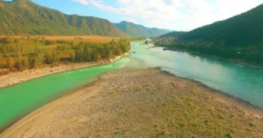 Güneşli yaz sabahında kayalarla birlikte taze, hızlı dağ nehri üzerinde alçak irtifa uçuşu..