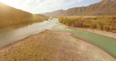 Güneşli yaz sabahında kayalarla birlikte taze, hızlı dağ nehri üzerinde alçak irtifa uçuşu..