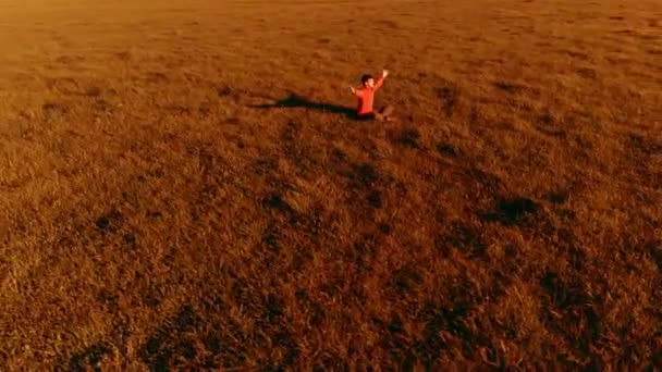 Vôo radial de baixa altitude sobre homem de ioga esporte na grama verde perfeita. Pôr do sol na montanha. — Vídeo de Stock