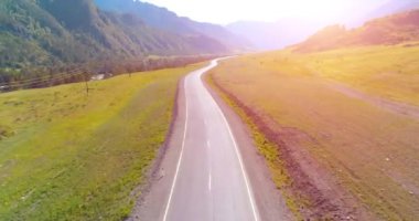 Dağda asfalt karayolu ve çayır üzerinde uçuş