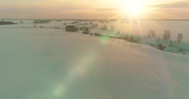 Вид с воздуха на холодный арктический полевой пейзаж, деревья с морозным снегом, ледяную реку и солнечные лучи над горизонтом. Экстремально низкая температура. — стоковое видео