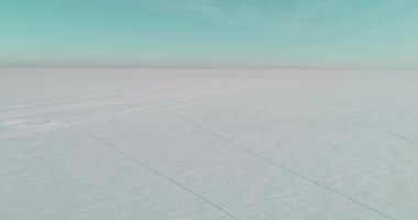 Soğuk kış manzarası kutup bölgesi, karla kaplı ağaçlar, ufukta buz nehri ve güneş ışınları. Aşırı düşük sıcaklık havası.