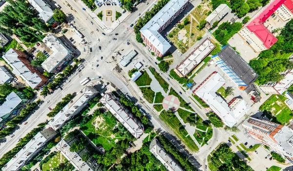 Vista aérea de la ciudad con encrucijadas y caminos, casas, edificios, parques y estacionamientos. Imagen panorámica soleada de verano —  Fotos de Stock