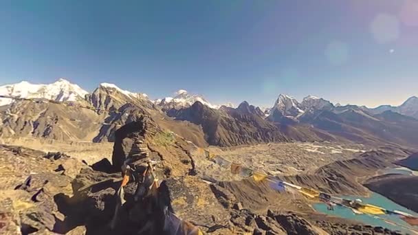 360 VR Gokyo Ri山顶。藏传佛教的旗帜。野生喜马拉雅山高海拔自然和高山山谷.岩石斜坡上覆盖着冰.全景运动 — 图库视频影像