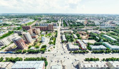 Kesişen yollar, evler, binalar, parklar ve otoparklar olan havacılık şehri manzarası. Güneşli yaz panoramik resmi