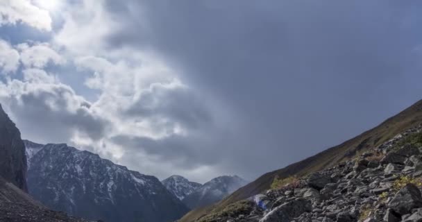 Timelapse van epische wolken in het bergdal in de zomer of herfst. Wilde eindeloze natuur en sneeuwstorm lucht. Zonnestralen boven de sneeuwtop — Stockvideo