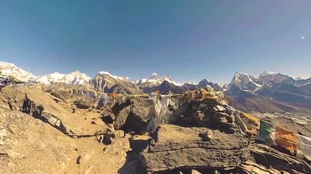 360 VR Gokyo Ri山顶。藏传佛教的旗帜。野生喜马拉雅山高海拔自然和高山山谷.岩石斜坡上覆盖着冰.全景运动 — 图库视频影像