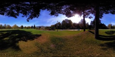 Bir şehir parkının UHD 4K 360 VR Sanal Gerçekliği. Sonbaharda ya da yaz gününde ağaçlar ve yeşil çimenler