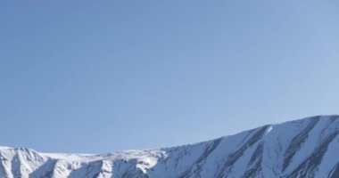 Güneşin kar dağının tepesinde kristal berrak gökyüzünde hareketinin zamanı. Sonbahar otlağında sarı çimenler. Vahşi sonsuz doğa..