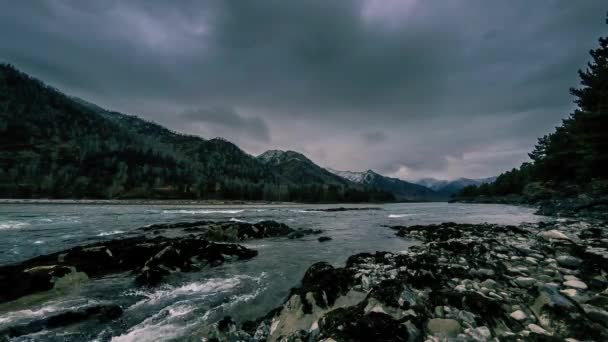 Tijdsverloop schot van een rivier in de buurt van bergbos. Enorme rotsen en snelle wolken. — Stockvideo