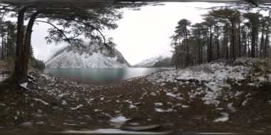 Dağ Gölü, kışın 360 Vr. Vahşi doğa ve dağ vadisi. Çam ağaçlarından yeşil orman ve gökyüzünde hızlı bulutlar.