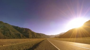 Yaz ya da sonbahar günbatımında gün batımında dağ yolu zamanı. Vahşi doğa ve kırsal alan.