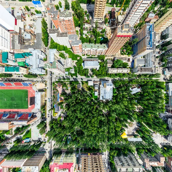 Aerial city view with crossroads and roads, houses, buildings, parks and parking lots. Sunny summer panoramic image — Stock Photo, Image