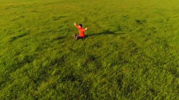 Vôo radial de baixa altitude sobre homem de ioga esporte na grama verde perfeita. Pôr do sol na montanha. — Vídeo de Stock