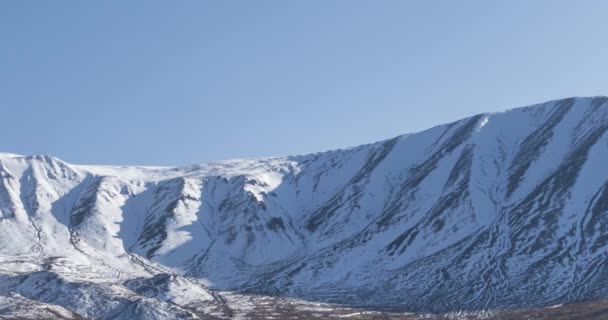 Timelapse del movimento del sole sul cielo cristallino sopra la cima della montagna della neve. Erba gialla al prato autunnale. Selvaggia natura infinita. — Video Stock