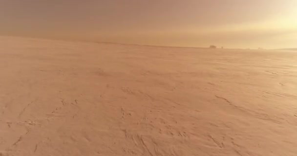 Vista aérea del frío paisaje invernal del campo ártico, árboles cubiertos de nieve helada, ríos de hielo y rayos de sol sobre el horizonte. Clima de baja temperatura extrema. — Vídeo de stock