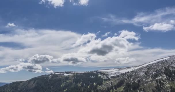 Tidsförskjutning av molnlandskap bakom bergstoppen. Snö, stenar, klippor och djupblå himmel. Hög höjd. — Stockvideo