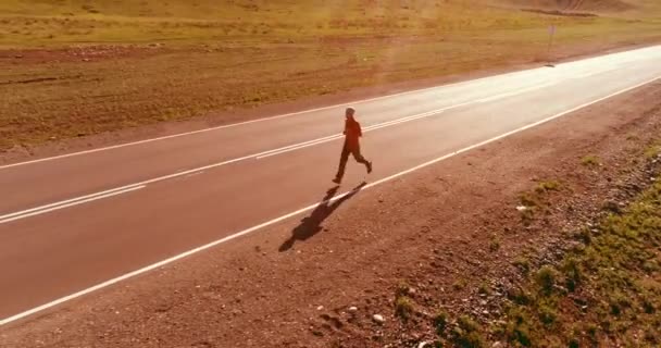 Vuelo de baja altitud frente al deportista en el camino perfecto de asfalto — Vídeo de stock