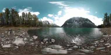 Dağ Gölü 'nün kış zamanı 360 Vr. Vahşi doğa ve dağ vadisi. Çam ağaçlarından yeşil orman ve gökyüzünde hızlı bulutlar.