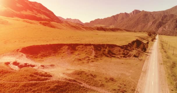 日当たりの良い夏の朝に空中農村部の山岳道路や牧草地。アスファルトハイウェイと川. — ストック動画