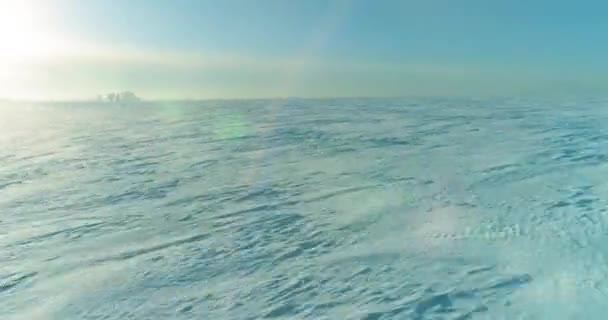 Légi kilátás hideg téli táj sarkvidéki területen, fák borított fagy hó, jég folyó és napsugarak horizonton. Extrém alacsony hőmérsékletű időjárás. — Stock videók